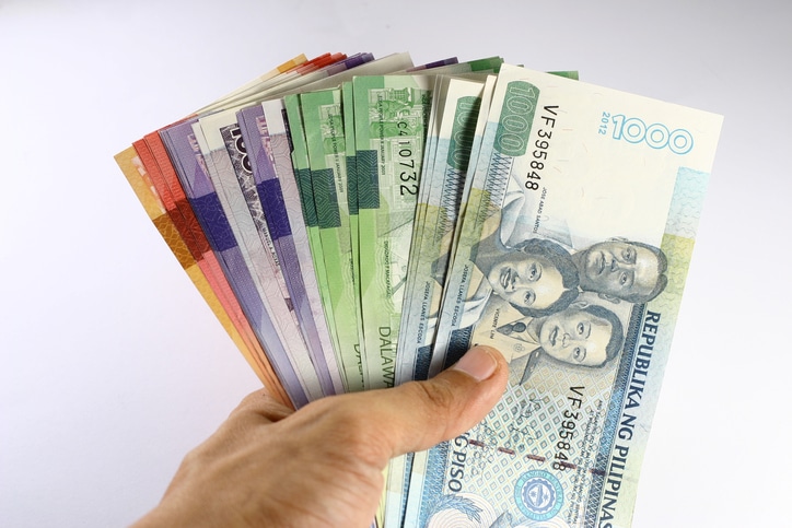 A photo of different Peso bills being held by a hand.
